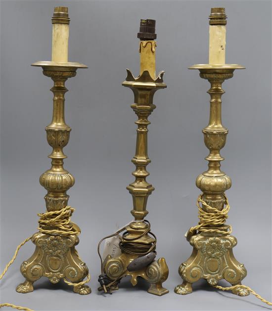 A pair of brass candlesticks and a similar one tallest 39.5cm